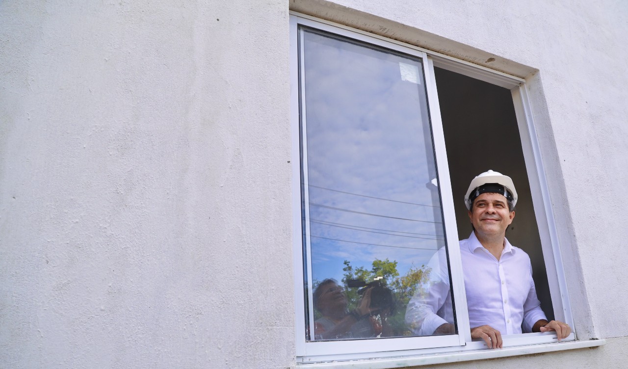 prefeito evandro posa na janela de um apartamento